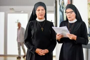 Schwester Hildegard (Andrea Sihler, re.) liest Schwester Hanna (Janina Hartwig) aus ihrem neuen Liebesroman vor. Stolpe lauscht (Markus Hering).