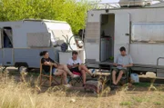 Begona Iglesias (li.) und ihr Sohn Hector (re.) entspannen nach der Arbeit zusammen mit ihrer Nachbarin Ana (Mi.) vor ihrem gemieteten Wohnmobil.