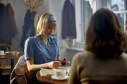 Marja (Thea Sofie Loch Næss) schreibt eine Postkarte an Erik.