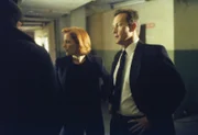 Scully (Gillian Anderson, M.) und Doggett (Robert Patrick, r.) erfahren von dem Häftling Martin Wells, dass er sich in der Zeit rückwärts bewegt.
