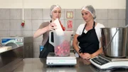 Lena und Alexandra wiegen ihre Erdbeeren ab.