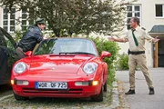 Hubert (Christian Tramitz, rechts) und Staller (Helmfried von Lüttichau, links) machen sich an dem Auto von Dr. Bähr zu schaffen.