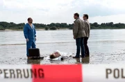 Pathologe Dr. Strahl (Christoph Tomanek, l.), Lars Englen (Ingo Naujoks, r.) und Finn Kiesewetter (Sven Martinek, M.) haben es mit einer Leiche am idyllischen Ostseestrand zu tun. Es handelt sich um den leblosen Körper des jungen Alexander Blohm (Daniel Axt).
