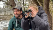 Lena sucht mit dem Fernglas nach ihrem Lieblingsvogel – Leander zeigt ihr, wo er steckt.