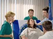 MDR Fernsehen IN ALLER FREUNDSCHAFT FOLGE 331, "Ihr Kinderlein kommet", am Montag (23.12.13) um 00:50 Uhr. Elena Eichhorn (Cheryl Shepard, im Bett liegend) hat zu schwache Wehen. Dr. Kathrin Globisch (Andrea Kathrin Loewig, links), Dr. Roland Heilmann (Thomas Rühmann, hinten Mitte) und die Hebamme (Komparsin,2. von rechts) haben den Gynäkologen Dr. Jürgen Leipold (Tom Quaas, vorn sitzend) hinzugezogen.