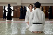 Der Ermittler Miyamoto (Hideaki Itō, re.) erklärt Jake (Ansel Elgort) die Regeln des Spiels.