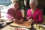 Viviane Ravanel (re.) zeigt ihrer Schwiegertochter Julie (li.), wie man die regionale Spezialität Farçon zubereitet.