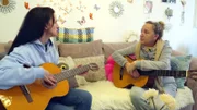 Ella (li.)  erhält ihre erste Gitarrenstunde von Eva