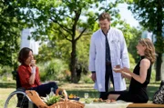 Katja Becker (Dominique Chiout, l.) und ihre beste Freundin Patricia (Sonja Baum, r.) amüsieren sich bei einem Picknic im Klinikpark. Dr. Marc Lindner (Christian Beermann, M.) bittet Katja, später ins Behandlungszimmer zu kommen.