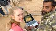 Forscher Avinash (Avinash Krishnan) zeigt Nina Aufnahmen von Kamerafallen. In Indien hält sich der Leopard häufig in der Nähe von Menschen auf.