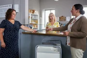 Frau Hiermeier (Annabel Faber, l.), die Urlaubsvertretung von Frau Stockl, bringt den Kolleginnen Lange (Sarah Thonig, M.) und Grasegger (Ursula Maria Burkhart, r.) ein Phantombild des zur Fahndung ausgeschriebenen Mannes.