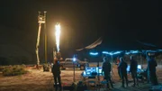 Die Menschen stehen und schauen den Flammen zu.