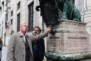 Ludwig Schaller (Alexander Held, l.) zeigt seinem italienischen Kollegen Commissario Quehenberger (Antonio Putignano, r.) die Stadt München und eine Statue Ludwig I.