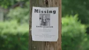 A missing poster of girl is on a post.