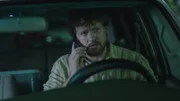 A man is on his phone in the car.