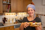 Gastgeberin Rahel Kremershof lädt zu einer typischen "Bergischen Kaffeetafel" ein.