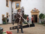 Hans (Lucas Reiber) trägt das Eisenbett ins Schloss.