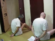 San Antonio, Texas: Gefangene, die mit Handschellen gefesselt auf dem Boden sitzen, während ihre Zellen durchsucht werden.