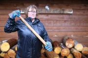 Mary Miller showing off her ax for cutting up wooden logs.