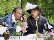 Der Lampenmann (Christian Tramitz, links) zeigt dem Soldaten Jakob (Christoph Letkowski), wie er den Weinkelch richtig halten muss.