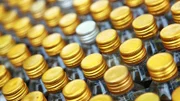 Rows of golden color bottle caps with shallow depth of field
