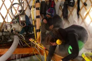 Emily Riedel reaches into the dive hole as Steve Riedel inspects gear.