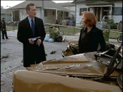 Scully (Gillian Anderson, r.) und Doggett (Robert Patrick, l.) rätseln, wie der Unfallwagen so stark beschädigt werden konnte.