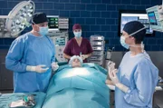 Als Dr. Marc Lindner (Christian Beermann, l.) erfährt, dass die Mandeloperation bei Valerie Linow (Sarah Maria Besgen, M.) rein präventiv ist, bricht er die Op ab (mit Katharina Nesytowa, r. und Komparsin, h.).