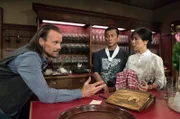 Tu (Maverick Quek, Mi.) kann sich einfach nicht entscheiden, ob er Constantins (Robert Besta, li.) Angebot nun annehmen soll oder nicht. Einerseits hängt er sehr am Löwen, andererseits läuft die Zusammenarbeit mit Eva momentan nicht wirklich rund. Oanh (Yi Chi, re.) hört ebenfalls sehr aufmerksam zu.