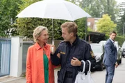 Polizeihauptmeister Mohr (Max Müller, M.) begleitet die Augenzeugin Beatrice Böttcher (Wookie Mayer, l.) aufs Präsidium, während Kommissar Hansen (Igor Jeftić, r.) am Tatort bleibt.