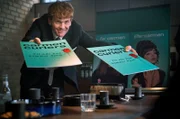 Axel (Morten Hee Andersen) präsentiert stolz die Werbekampagne der „Carmen Curlers“.