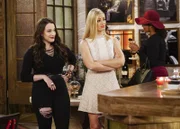 Max (Kat Dennings, l.) versichert Caroline (Beth Behrs, M.), dass sie mit ihrem Date problemlos abends ins Kino gehen kann, nicht ahnend, dass genau dann eine Studentinnen-Verbindung in der Bar aufschlägt ...