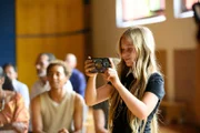 Sunny (Leni-Sofie Rocek, rechts) wollte die Aufführung lieber filmen als mit auf der Bühne zu stehen. Das Publikum (u.a. Toms Bruder Ben (Noel Okwanga, 2. von rechts) wartet gespannt, dass es endlich losgeht.