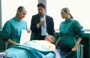Wie kam es zu dem tödlichen Autounfall? Kommissar Joe Hoffer (Jörg Gudzuhn, M.) erfährt von Dr. Robert Kolmaar (Ulrich Mühe, l.) und Dr. Judith Sommer (Gesine Cukrowski, r.), dass der Deutschamerikaner David Taylor (Matthew Burton) an einer Kohlenmonoxidvergiftung starb.