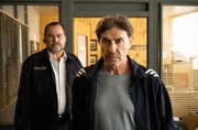 Gerhard Jäger (Markus John, l.) führt Vickie Markos (Mark Zak, r.) Richtung Ausgang.