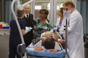Leo Polson (Charles Robinson, liegend) wird mit schweren Rückenproblemen eingeliefert. Jo (Camilla Luddington, 2.v.r.), Meredith (Ellen Pompeo, l.) und Owen (Kevin McKidd, r.) kümmern sich um ihn, während seine Frau Angelica (Judyann Elder, M.) und sein Portier Vincent (Robert Pine, 2.v.l.) sich um ihn sorgen ...