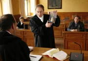 Staatsanwalt Claus Dahlheimer führt ein Beweisstück an, um Pfarrer Braun des Mordes anzuklagen.