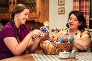 Monika (Christine Reimer, rechts) präsentiert Sophia (Patricia Freund, links) ihre selbstgehäkelten Püppchen.