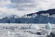 Longyearbyen Lokalstyre, Svalbard - The Arctic Explorer Leone boat is dwarfed by the scale of the glaciers in Svalbard.