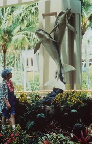 Fasziniert betrachtet Timmy (Mike Hughes) im Garten des Hotels eine Riesen-Skulptur, die spielende Delphine darstellt.
