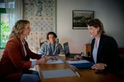 Die Notarin Pippig (Minna Wündrich, r.) hat für Antonia (Lara Joy Körner, l.) und ihren Sohn Linus (Emil Baikousis, M.) inzwischen alle Papiere vorbereitet.