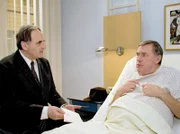 Dr. Konrad Fuchs (Gerd Udo Feller, links) hat im Nachlass seiner Frau eine Hotelrechnung gefunden, die ihn vermuten lässt, dass seine verstorbene Frau ein Verhältnis mit einem anderen Mann hatte. Als er seinen Bruder Henning Fuchs (Wilfried Dziallas) danach fragt, weiß er angeblich von nichts.