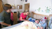 Eva Brenner und John Kosmalla begrüßen den kleinen Jared (3), der seit einigen Jahren schwerst behindert ist.