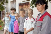 Luzia Kuppelwieser erklärt Kindern die Stallarbeit am Hof.