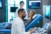 Dr. Matteo Moreau (Mike Adler, v.) und Dr. Theresa Koshka (Katharina Nesytowa, h.) führen bei Natalie Reichelt (Rike Kloster, r.) eine Ultraschall-Untersuchung durch.