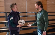 Hannes Seela (André Dietz, li.) fordert vehement einen Freistoß in einem Trainingsspiel für seinen Sohn. Trainer David Ziegler (Matthias Schloo, re.) findet seine Reaktion völlig übertrieben und fordert ihn auf, die Turnhalle zu verlassen.
