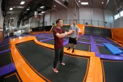 "PUR+"-Moderator Eric Mayer versucht einen Rückwärtssalto auf dem Trampolin zu lernen. Unterstützt wird er von seinem Trainer Amadei Weiland. Volle Konzentration kurz vor dem Absprung.