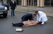 Martin Stein (Bernhard Bettermann, re.) und Kai Hoffmann (Julian Weigend, 2.v.li.) sind in einem Streit aneinander geraten. Maria Weber (Annett Renneberg, liegend) wollte zu ihnen eilen und hat dabei ein Auto übersehen. Der Autofahrer (Komparse, li.) konnte nicht mehr schnell genug bremsen.