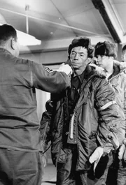 Einsatzkräfte, die nach verlorenen Atombomben auf kontaminiertem Gelände suchen, werden mit einem Geigerzähler kontrolliert. Einsatzkräfte, die nach verlorenen Atombomben auf kontaminiertem Gelände suchen, werden mit einem Geigerzähler kontrolliert.