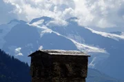 Blick auf die Kaukasusberge mit einem Wehrturm im Vordergrund